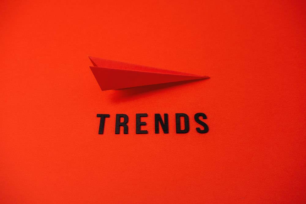 Global World Trends, Top New trends, forecasting. Word trends and red paper plane on red background.